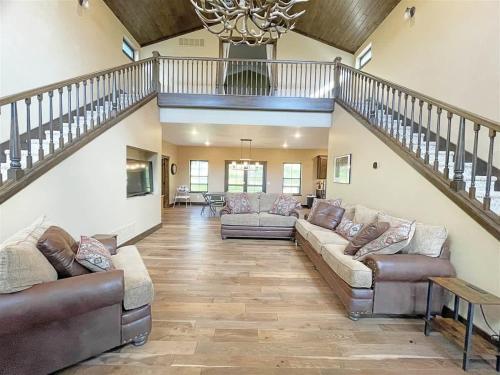 a living room with two couches and a staircase at Bishop Mountain Lookout in Hill City