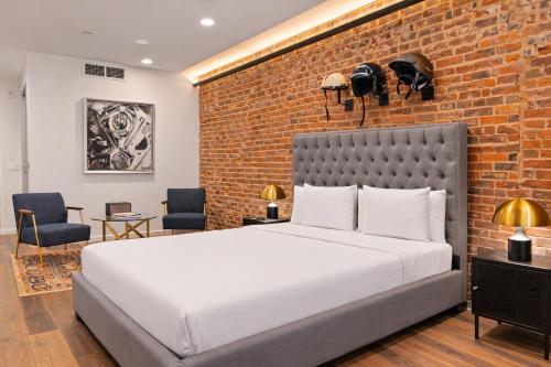 a bedroom with a large bed and a brick wall at Sosuite at The Queen - Queen Village in Philadelphia
