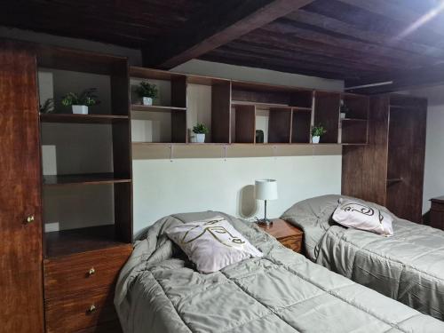two beds in a room with wooden shelves at Casa de Chacha in Guanajuato