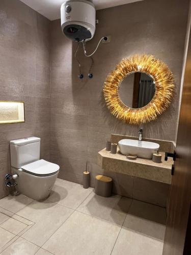 a bathroom with a toilet and a sink and a mirror at 44 Inn in Dahab