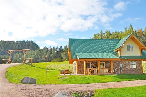 a house with a green roof and a playground at Cottage at Storm Mountain #5 in Hill City