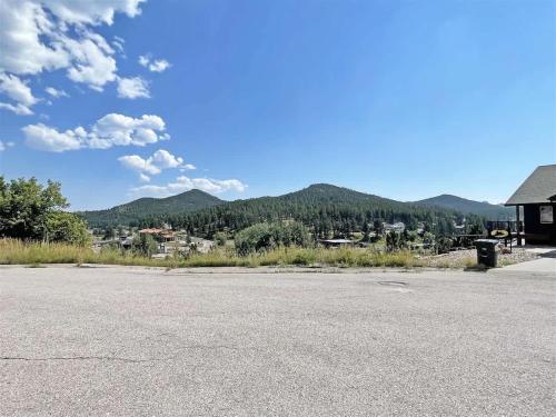 an empty parking lot with mountains in the background at Gold Mill in Hill City