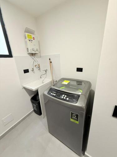 a small white bathroom with a sink and a machine at Total Comfort Studio Santa Rosa in Santa Rosa de Cabal