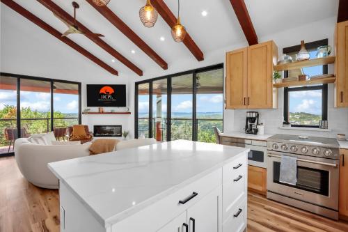 a kitchen with white appliances and a living room at Canyon Tree House in Canyon Lake