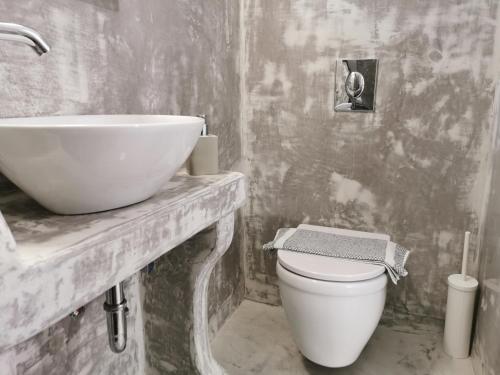 a white bathroom with a sink and a toilet at Meltemi Chora Amorgos in Amorgos