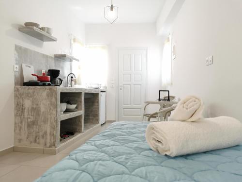 a white room with a bed and a kitchen at Meltemi Chora Amorgos in Amorgos