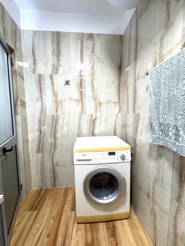 a washer and dryer in a bathroom with a wall at Beach Apartments Durres in Durrës