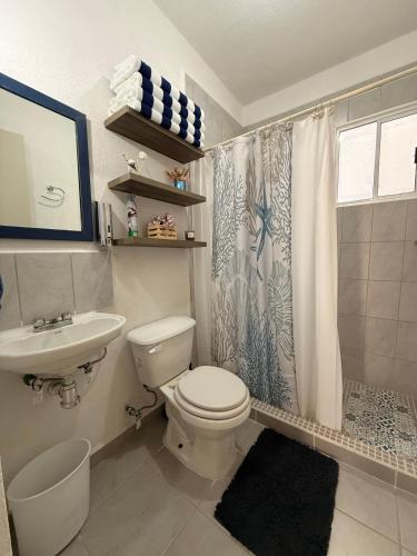a bathroom with a toilet and a sink and a shower at La casa Azul in Acapulco