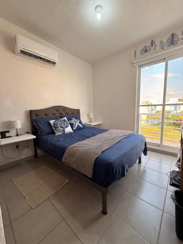 a bedroom with a bed and a large window at La casa Azul in Acapulco