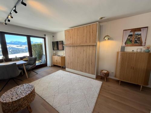 a living room with a large window and a table and chairs at Neu - Ferienwohnung Allgäuparadies - Traumhafte Aussichten mitten in der Natur des Westallgäus in Oberreute