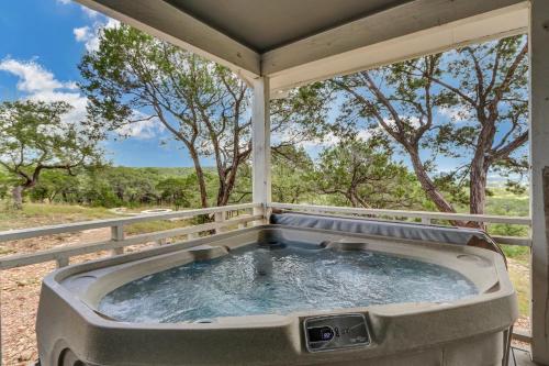 a hot tub on a porch with trees at Casa Cielo in Wimberley