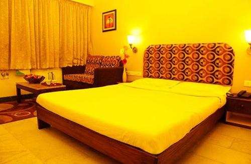 una camera con un grande letto e un divano di Hotel Vales Park a Dindigul