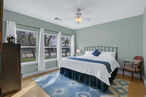 a bedroom with a bed and two windows at Casa Robles- The Bluebonnet in Wimberley