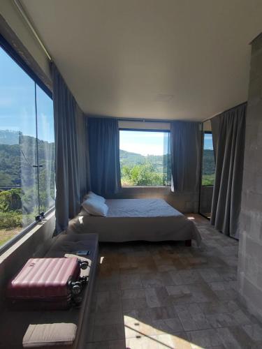 a bedroom with a bed and a large window at Recanto Colina in Picada Cafe