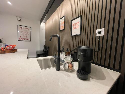 a kitchen counter with a coffee maker on a counter top at Sydney Homestay in Mölndal