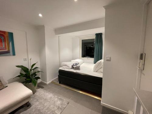 a bedroom with a bed with a mirror and a couch at Sydney Homestay in Mölndal
