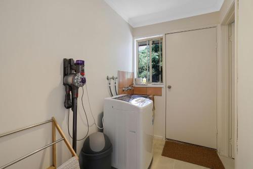 a laundry room with a washing machine and a window at Cowes Monash Hideaway in Cowes