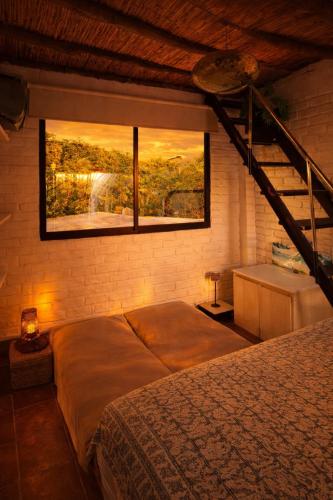a bedroom with a bed and a large window at Hugo's Place in Taganga