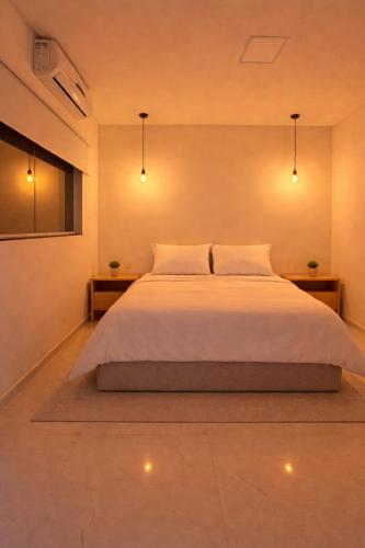 a bedroom with a large white bed with two lights at Green House in Juazeiro do Norte