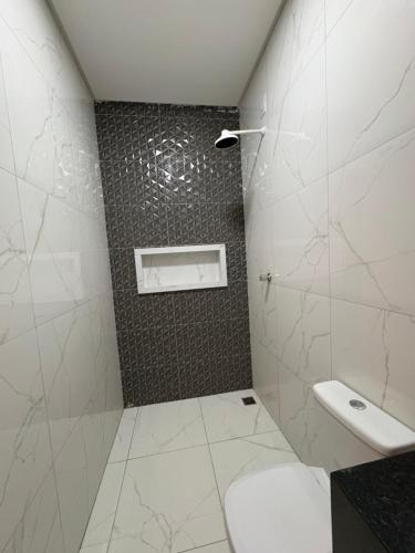 a white bathroom with a toilet and a shower at Green House in Juazeiro do Norte