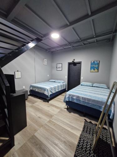 ein Zimmer mit zwei Betten und einem Fernseher in der Unterkunft Casabela in Comayagua