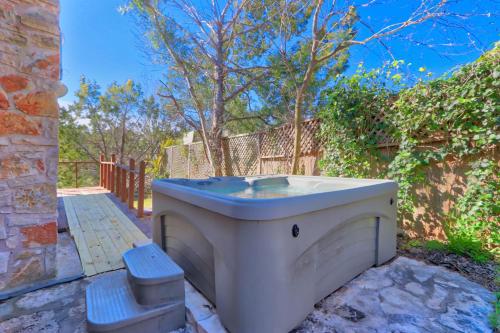 a white bath tub sitting next to a fence at Clearwater Log Home in Wimberley