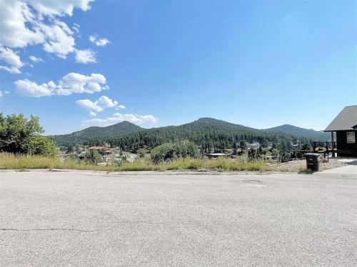 an empty parking lot with mountains in the background at Prospector in Hill City