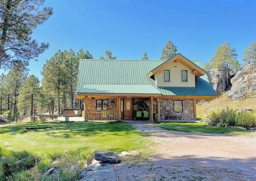 a house with a green roof and a yard at Granite Ridge Cabin in Keystone