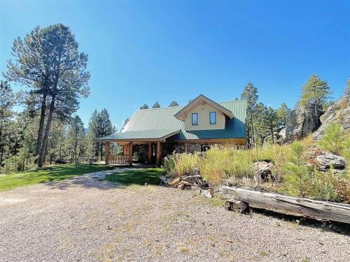 a house on a hill with a gravel driveway at Granite Ridge Cabin in Keystone