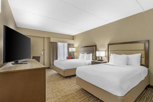a hotel room with two beds and a flat screen tv at Best Western Holiday Lodge in Clear Lake