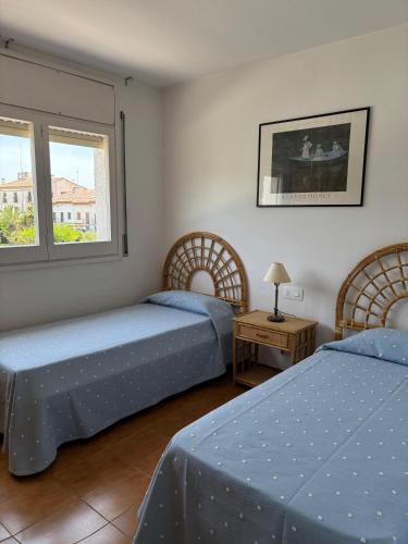 a bedroom with two beds and a table and two windows at ALTAFULLA MAR Pescadors in Altafulla