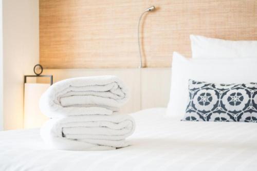 a stack of towels sitting on top of a bed at Hotel Noto Marina Meeting Vista Mare in Noto Marina