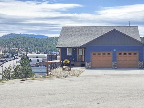 a blue house with a garage and a lake at Iron Horse Lookout in Hill City