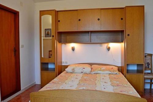 a bedroom with a large bed with a wooden headboard at Kuća za odmor STIPE in Pag