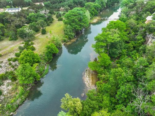 an aerial view of a river with trees at Clutter Falls Retreat - Guest House in New Braunfels