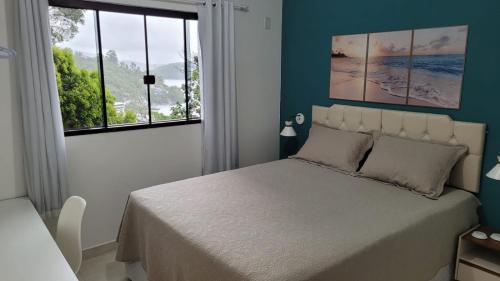 a bedroom with a large bed and a window at Marques Home in Porto Belo