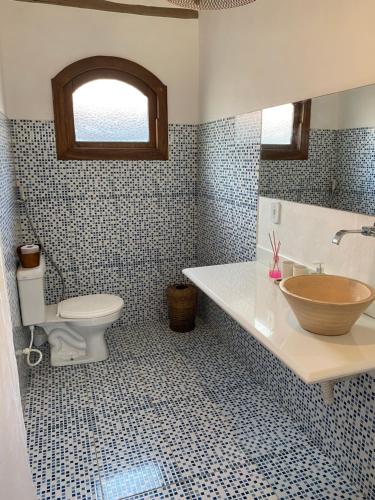 a bathroom with a sink and a toilet and a tub at Chalé Rosa in Trancoso