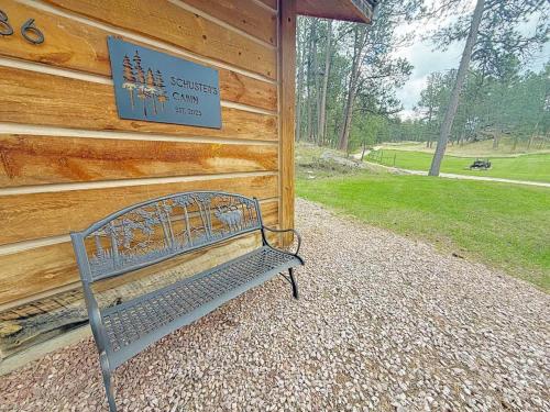 a bench sitting in front of a wooden building at Schuster's Cabin in Custer