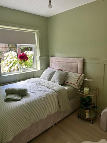 a bedroom with a large bed with a window at The Greenway Getaway in Abbeyside