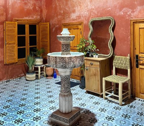 a bathroom with a table and a mirror in a room at Riad Sor in Essaouira