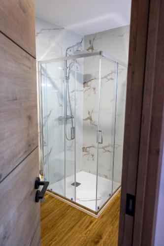 an open door with a glass shower in a room at Trio Living Residences in Vila Real