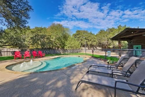 a swimming pool with chairs and a fountain at Wimberley Log Cabins Resort and Suites- Unit 3 in Wimberley