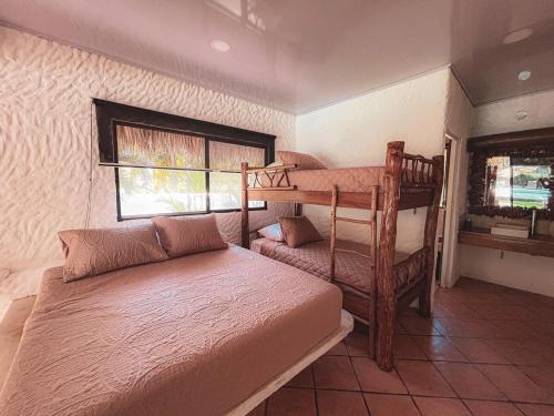 a bedroom with two bunk beds and a window at Candelaria 5 Moterrico in Taxisco