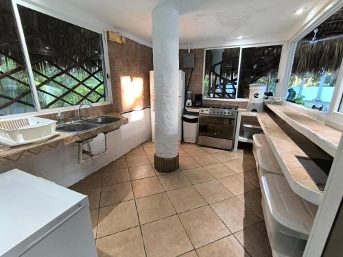 a kitchen with a sink and a counter with windows at Candelaria 5 Moterrico in Taxisco