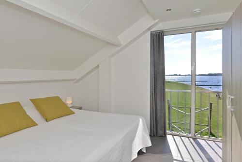 カンペルラントにあるPenthouse XL Veerse Meerの白いベッドルーム(ベッド1台、大きな窓付)