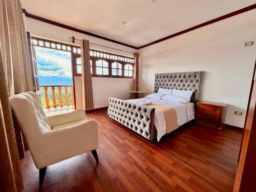 a bedroom with a bed and a chair and a window at Andina Amazon Lodge in Chachapoyas