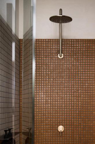 a bathroom with a shower with a glass wall at The Black Dolphin Motel in Merimbula