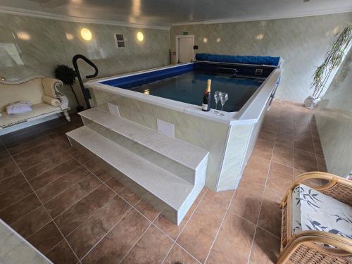 a swimming pool in a room with stairs and a table at Glamis House in Forfar