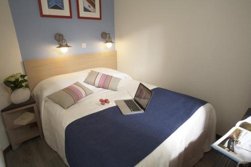 une chambre d'hôtel avec un lit avec un ordinateur portable dessus dans l'établissement Residence Le Beach - maeva Home, à Trouville-sur-Mer