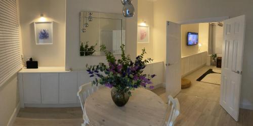 a vase of flowers sitting on a table in a room at By the Sea in Redcar